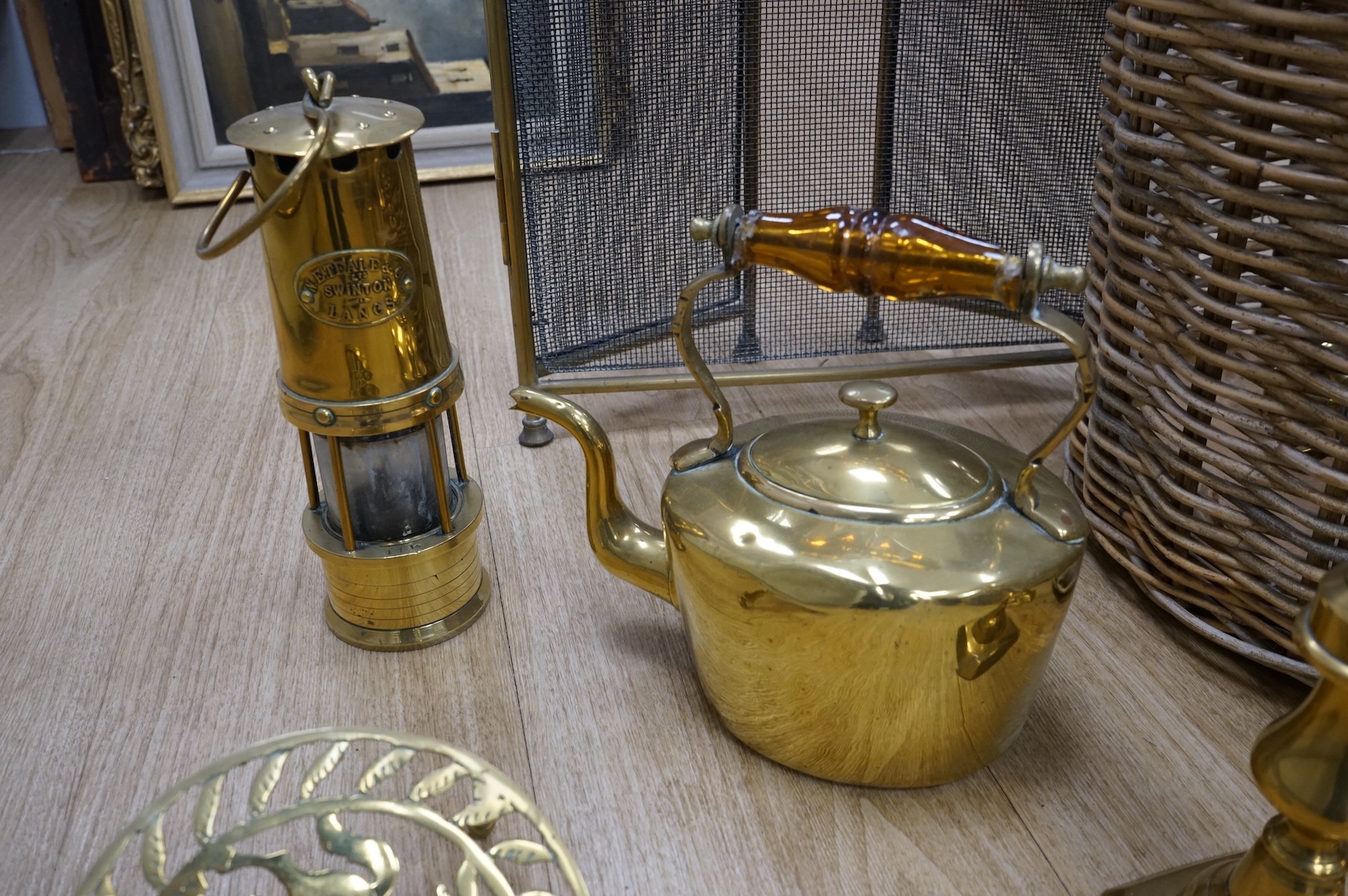 A fire brass guard, pair of candlesticks, kettle, miner's lamp etc, fire guard 54cm high.